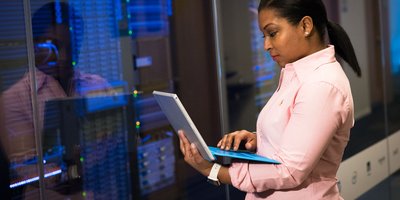 Engineer with a laptop in a server room (Pexels 1181341)